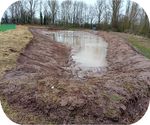 Scrape completed - a wet area in a muddy marshland