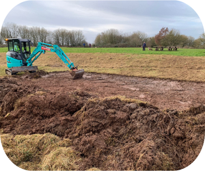 A small digger digs up dirt