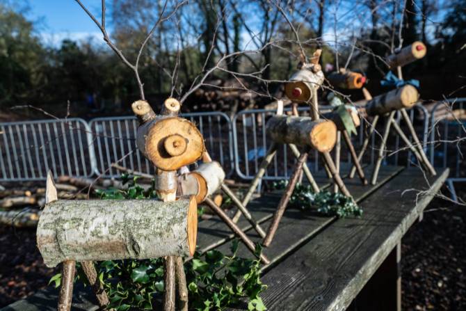 A line up of reindeers made out of logs and branches