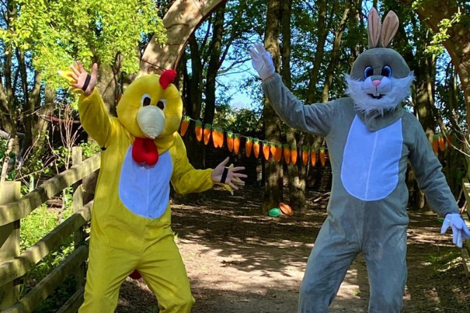 Two people in costumes. One is a bunny and the other is a chick.