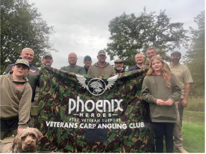 Phoenix veterans angling club holding up a flag with the name on